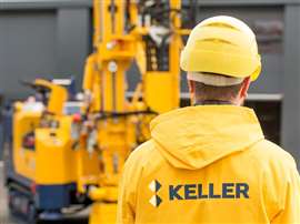 A Keller group worker stands in front of a piling rig (Image courtest of Keller Group)