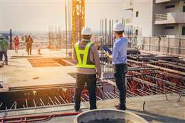 Construction workers talking on building site 