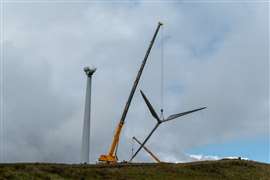 A crane is used to dismantle a wind turbine