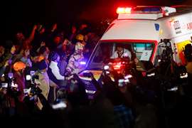 An ambulance transports survivors following the rescue of construction workers trapped inside a collapsed tunnel in the Himalayas in India