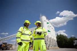 two people outside concrete plant