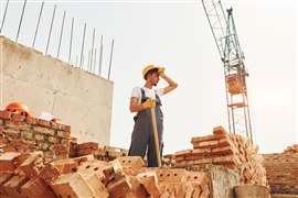 A construction worker wipes his brow during a project.