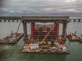 An in-river section of the Champlain Bridge being removed uses barges and jacking systems