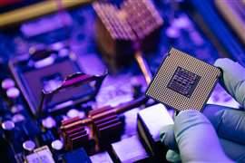 Engineer showing a computer microchip on motherboard background. Electronic circuit board with processor.