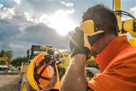 A construction machinery operator wearing hearing protection