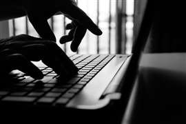 hacker or cyber crime hand reaching, stealing information on laptop, attack signifying internet theft while using online banking, anonymous business in technology internet and networking