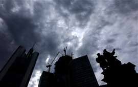 Des nuages sombres sont visibles au-dessus du chantier de construction du gratte-ciel « 4 Frankfurt » à côté de la statue de l'inventeur allemand Johannes Gutenberg et de la tour Commerzbank à Francfort, en Allemagne, le 19 juillet 2023. REUTERS/Kai Pfaffenbach/Photo d'archives