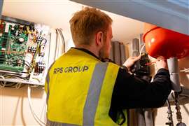 Ein Installateur arbeitet an der Nachrüstung einer Wärmepumpe in einem Wohngebäude