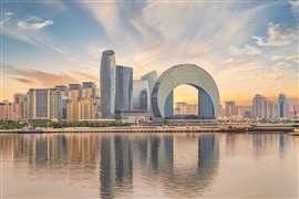 The sun sets behind the Baku, Azerbaijan, skyline, which features the distinct Crescent Development Project