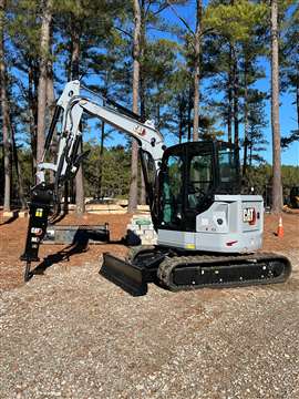Una miniexcavadora Caterpillar pintada en gris centenario