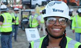 Una trabajadora de la construcción de Turner con casco y sonriendo