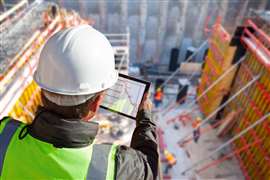 ouvrier utilisant la technologie sur le chantier
