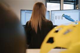 Una donna che dà le spalle alla telecamera osserva un modello computerizzato del corpo di un operaio edile caduto.