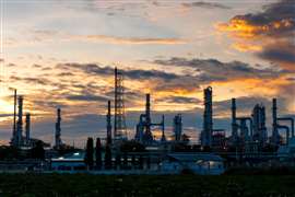 An oil and gas refinery at sunset