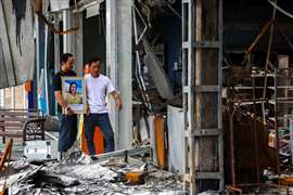 Komsan Prachan, 40, who lost his wife and two children when a Cambodian artillery shell slammed into a gas station, stands in front of the attached 7-Eleven convenience store that was also destroyed in Sisaket province, Thailand, 30 July. Image: Reuters/Athit Perawongmetha via Reuters Connect