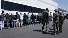 Detainees are made to stand against a bus before being handcuffed, during a raid by federal agents during a raid on a Hyundai Motor construction site in Georgia, USA, where about 300 South Koreans were among 475 people arrested. (Image: U.S. Immigration and Customs Enforcement/Handout via REUTERS/File Photo)