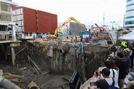 Officials continue recovery work on Samsen Road in front of Vajira Hospital, Bangkok, Thailand, after the street collapsed into a large sinkhole. Bangkok’s governor Chadcart Sittipunt suggested that construction work on the MRT Purple Line under the city could have contributed to the collapse. Roadworks were also underway at the time. (Image: Teera Noisakran/Sipa USA via Reuters Connect)