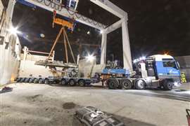 guindaste de pórtico levantando pedaços de TBM do trailer