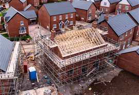 Aerial view of houses under construction with roof beams exposed