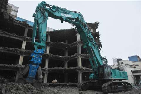 The Kobelco SK1300DLC ultra-high reach demolition machine taking down a tower block