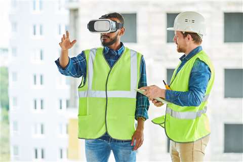 A man in PPE using a VR head set