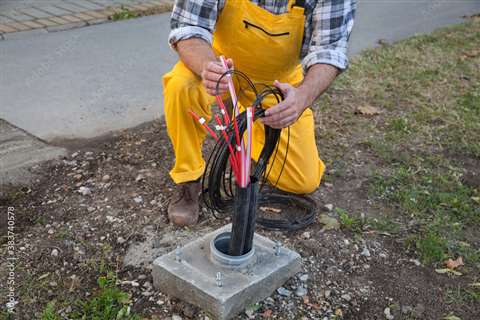 A worker installs fibre optic cables.