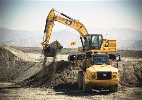 New Cat 323 excavator loading Cat articulated truck extended sky