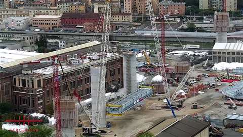 Aerial view of Fagioli using a pair of white and red 600 tonne crawler cranes to install one of the 19 steel and concrete spans of the new Genoa bridge